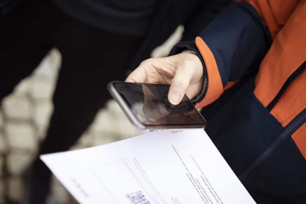 To deltakere samarbeider med kart og mobil under BRAVE sin AppChallenge