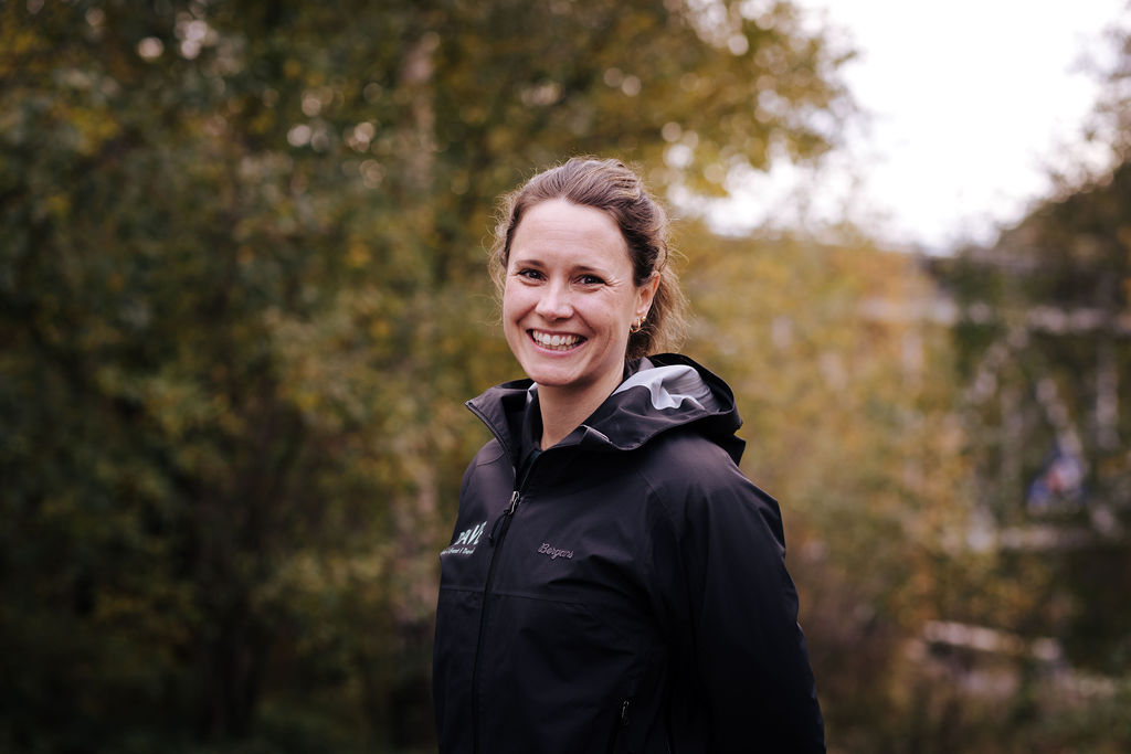 Profilbilde av dame med brunt hår i hestehale som smiler