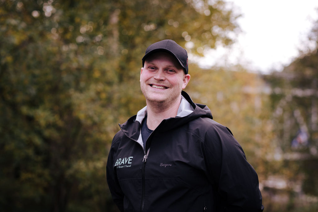 Profilbilde av mann med caps som smiler